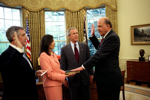 White House Chief of Staff Andrew Card swears in John Negroponte as the first Director of National Intelligence as President George W. Bush looks on Thursday, April 21, 2005, in the Oval Office. Dina Powell, Assistant to the President for Presidential Personnel, holds the Bible. White House photo by Eric Draper