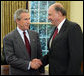 President George W. Bush offers congratulations to John Negroponte, Thursday, April 21, 2005, in the Oval Office after Mr. Negroponte was sworn in as the Director of National Intelligence. White House photo by Eric Draper
