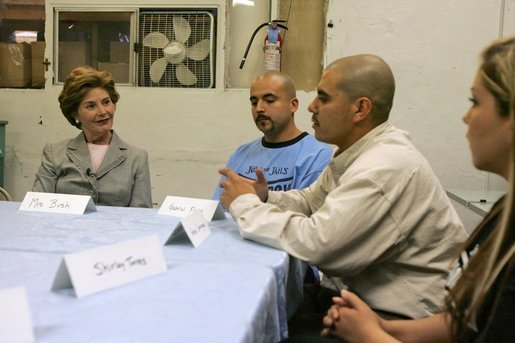 Laura Bush talks with, from left, Gabriel Flores, Archie Dominguez and Shirley Torres during a discussion at Homeboy Industries in Los Angeles April 27, 2005. Homeboys Industries is an job-training program that educates, trains and finds jobs for at-risk and gang-involved youth. White House photo by Krisanne Johnson