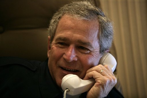 President George W. Bush smiles as he offers congratulations to Britain's Prime Minister Tony Blair during a phone call from Air Force One Friday, May 6 2005. White House photo by Eric Draper