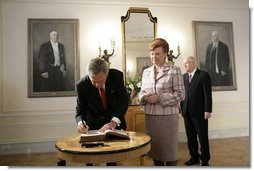 President George W. Bush signs a guest book after Latvian President Vaira Vike-Freiberga presented him the Order of the Three Stars, First-Class at Riga Castle in Riga, Latvia, Saturday, May 7, 2005. Established in 1924 to commemorate the founding of the Latvian State, the medal is awarded to recognize outstanding civil merit in the service of Latvia. White House photo by Eric Draper