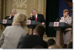 From left, Lithuanian President Valdas Adamkus, President George W. Bush and Latvia President Vaira Vike-Freiberga adjust their earphones to hear interpreters during a question and answer session Saturday, May 7, 2005, in Riga, Latvia.  White House photo by Eric Draper