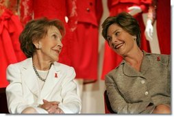 Laura Bush and former First Lady Nancy Reagan share a moment Thursday, May 12, 2005, at the John F. Kennedy Center for the Performing Arts during the unveiling of The Heart Truth’s First Ladies Red Dress Collection.  White House photo by Krisanne Johnson