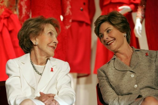 Laura Bush and former First Lady Nancy Reagan share a moment Thursday, May 12, 2005, at the John F. Kennedy Center for the Performing Arts during the unveiling of The Heart Truth’s First Ladies Red Dress Collection. White House photo by Krisanne Johnson