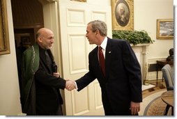 President George W. Bush welcomes Afghanistan President Hamid Karzai into the Oval Office Monday, May 23, 2005, following his arrival to the White House.  White House photo by Eric Draper