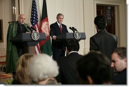 President George W. Bush and Afghan President Hamid Karzai field a question from a reporter Monday, May 23, 2005 in the East Room of the White House.  White House photo by Eric Draper