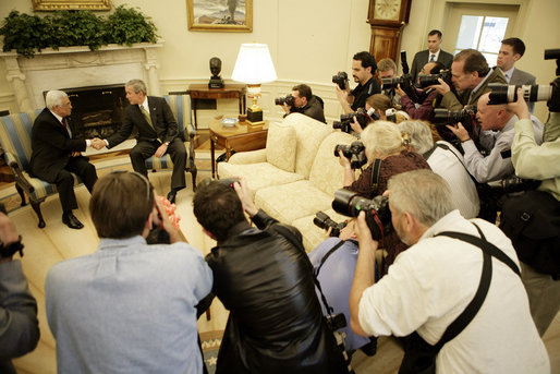 President George W. Bush shakes hands with President Mahmoud Abbas of the Palestinian Authority Thursday, May 26, 2005, as the press records the moment in the Oval Office of the White House. White House photo by Eric Draper