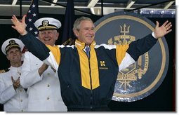 President George W. Bush tries on a Navy jacket during U.S. Naval Academy graduation ceremony in Annapolis, Md., Friday, May 27, 2005.  White House photo by Paul Morse