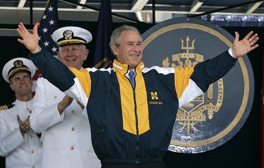 President George W. Bush tries on a Navy jacket during U.S. Naval Academy graduation ceremony in Annapolis, Md., Friday, May 27, 2005. White House photo by Paul Morse