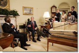As the media looks on, President George W. Bush and South Africa's President Thabo Mbeki visit in the Oval Office Wednesday, June 1, 2005.  White House photo by Eric Draper