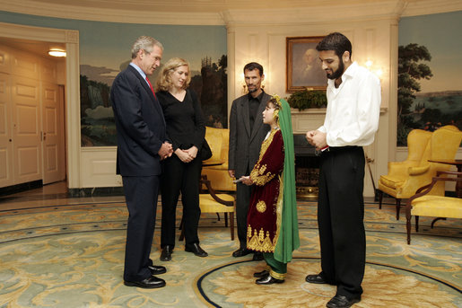 President George W. Bush greets 11-year-old Vasila Hossaini in the Diplomatic Reception Room of the White House Thursday, June 2, 2005. The Afghan youth recently underwent surgery to correct a congenital heart defect that allows un-oxygenated blood to circulate through her body. Project Kids Worldwide, a non-profit organization, that helps provide surgery and other medical care to impoverished children suffering from heart defects, helped to arrange the meeting with the President. With her is her father, Arman, in dark jacket; filmmaker Stacia Teele, who is documenting Vasila's illness and trip, and Hameed Said, their interpreter. White House photo by Paul Morse