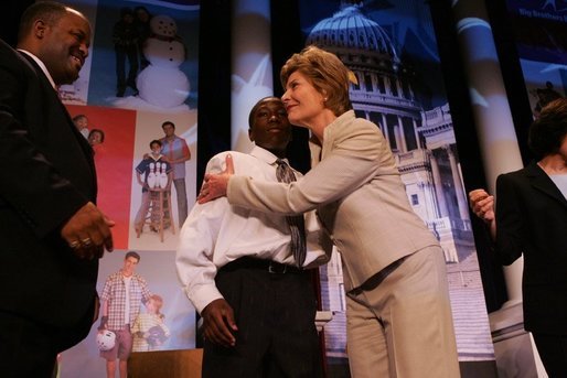 Laura Bush attends the Opening Session of the 2005 National Big Brothers Big Sisters Conference, June 9, 2005, at the Marriott Wardman Park Hotel. Washington, D.C. On-stage participants include: Vincent "Vinny" Thomas, Big Brother, left, ; and Parry Elliott, Little Brother, 13-years-old, being embraced by Mrs. Bush. White House photo by Krisanne Johnson