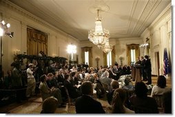 The media crowds into the East Room of the White House Monday, June 20, 2005, as President George W. Bush, European Union President Jean-Claude Juncker, left, and European Commission President Jose Manuel Barroso hold a joint press conference.  White House photo by Eric Draper