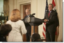 President George W. Bush and Prime Minister Ibrahim Jaafari listen to a question from the media Friday, June 24, 2005, during a press availability in the East Room of the White House.  White House photo by Eric Draper