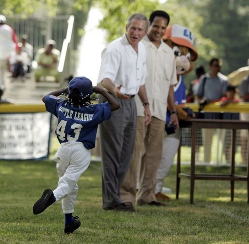 Shaquana Smith holds onto her hat as she runs to President George W. Bush and White House Tee Ball Commissioner Barry Larkin after her Memphis Red Sox played the Black Yankees of Newark during Sunday's "Tee Ball on the South Lawn." White House photo by Paul Morse