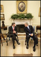 President George W. Bush and German Chancellor Gerhard Schroeder talk just before meeting with the press in the Oval Office Monday, June 27, 2005. White House photo by Eric Draper