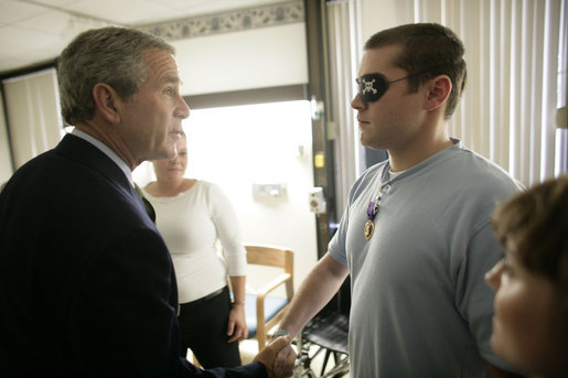 President George W. Bush shakes hands with Cpl. Matthew James after awarding the Manassas, Va., soldier with a Purple Heart during a visit Friday, July 1, 2005, to Walter Reed Army Medical Center. Cpl. James is recovering from injuries received while serving in Operation Iraqi Freedom. White House photo by Eric Draper