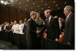 President George W. Bush shakes hands Monday, July 11, 2005, with Robert Mueller, Director of the Federal Bureau of Investigation as Porter Goss, right, Director of the Central Intelligence Agency, looks on. The President had just finished speaking on the war on terrorism at the FBI Academy in Quantico, Va.  White House photo by Eric Draper