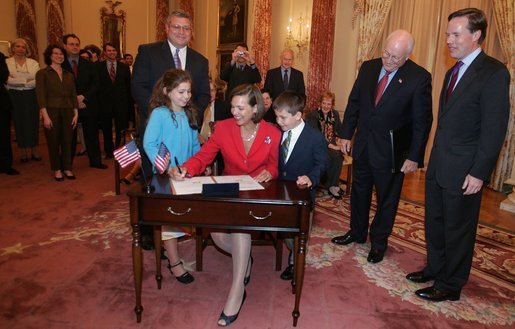 Vice President Dick Cheney and Undersecretary of State Nicholas Burns watch as Toria Nuland signs two Appointment Affidavits Wednesday, July 13, 2005, following her swearing-in as the Ambassador of the United States of America to the North Atlantic Treaty Organization during a ceremony at the U.S. State Department. Mrs. Nuland's family is pictured standing next to her. White House photo by David Bohrer