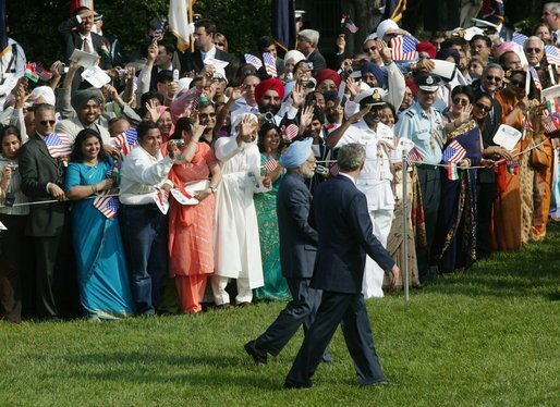 President George W. Bush and India's Prime Minister Dr. Manmohan Singh are cheered by invited guests, Monday, July 18, 2005 on the South Lawn of the White House, during the official arrival ceremony for Prime Minister Singh. White House photo by Lynden Steele