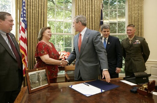 President George W. Bush shakes the hands of Janet and Bill Norwood after signing into law H.R. 1001, the Naming of the Sergeant Byron W. Norwood Post Office Building, designating the US Postal Service facility in Pflugerville, Texas, in honor of their 25-year-old son who died in combat in Iraq. Joining the Norwoods and the President for the signing are Congressman Michael McCaul, R-Texas, and First Lt. T.Ryan Sparks, 3rd Battalion, 1st Marines. White House photo by Eric Draper