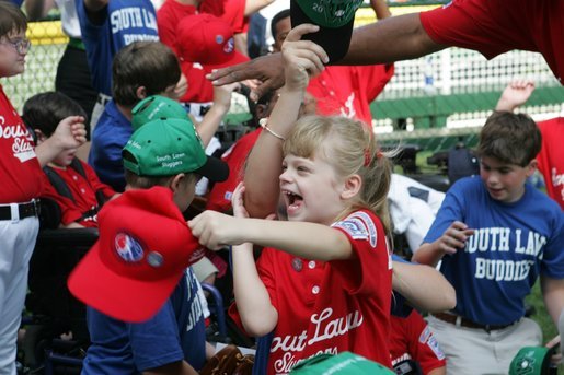 A young ballplayer from the West University Little League Challengers from Houston, Texas, cheers with her team Sunday, July 24, 2005, at a Tee Ball game on the South Lawn of the White House. White House photo by Carolyn Drake