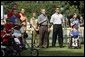 President George W. Bush listens to the National Anthem before a Tee Ball game on the South Lawn of the White House between the District 12 Little League Challengers from Williamsport, PA and the West University Little League Challengers from Houston, Texas on Sunday July 24, 2005. White House photo by Paul Morse