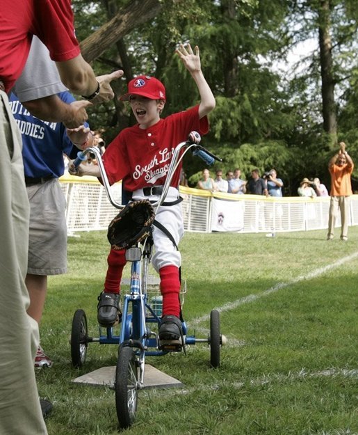 A player from the West University Little League Challengers from Houston, Texas, is welcomed as he crosses homeplate to score a run, Sunday, July 24, 2005, during a Tee Ball game on the South Lawn of the White House. White House photo by Paul Morse
