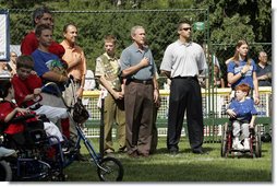 President George W. Bush listens to the National Anthem before a Tee Ball game on the South Lawn of the White House between the District 12 Little League Challengers from Williamsport, PA and the West University Little League Challengers from Houston, Texas on Sunday July 24, 2005.  White House photo by Paul Morse
