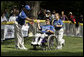 A player from the District 12 Little League Challengers from Williamsport, PA is helped to home plate by her buddy during a Tee Ball game on the South Lawn of the White House on Sunday July 24, 2005. White House photo by Paul Morse