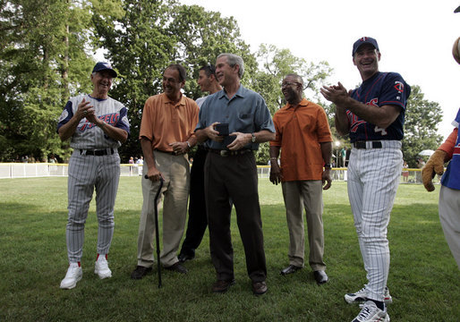 President George W. Bush laughs with Major League Baseball Hall of Fame players Ozzie Smith and Paul Molitor and former umpire Steve Palermo while congratulating Challenger Tee Ball players after a game on the South Lawn of the White House on Sunday July 24, 2005. White House photo by Paul Morse