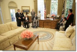 President George W. Bush gives a tour of the Oval Office after the signing of the Presidential Proclamation to Commemorate the 15th Anniversary of the Americans with Disabilities Act in the Oval Office Tuesday, July 26, 2005. President George H. W. Bush is pictured at center, left.  White House photo by Eric Draper