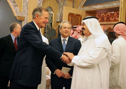 Former President George H.W. Bush, left, shake hands with newly crowned King Abdullah, right, during a retreat at King Abdullah's Farm in Riyadh, Saudi Arabia Friday, August 5, 2005, following the death of his half-brother King Fahd who passed away August 1, 2005. Interpreter Gamal Helal, center, is also pictured. White House photo by David Bohrer