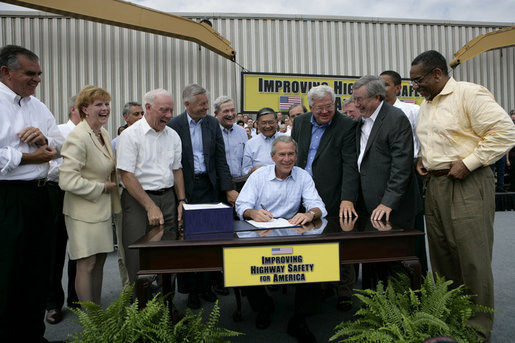 President George W. Bush signs the Transportation Equity Act, at the Caterpillar facility in Montgomery, Ill., Wednesday, Aug. 10, 2005. Joining the President on stage in front row, from left, are Congressman Ray LaHood, R-Ill.; Congresswoman Melissa L. Bean, D-Ill.; Congressman Jim Oberstar, D-Minn.; Congressman Tom Petri, R-Wis.; Senator Kit Bond, R-Mo.; U.S. Transportation Secretary Norman Mineta; Speaker of the House Dennis Hastert, R-Ill.; Congressman Bill Thomas, R-Calif.; and Congressman Bobby Rush, D-Ill. White House photo by Eric Draper