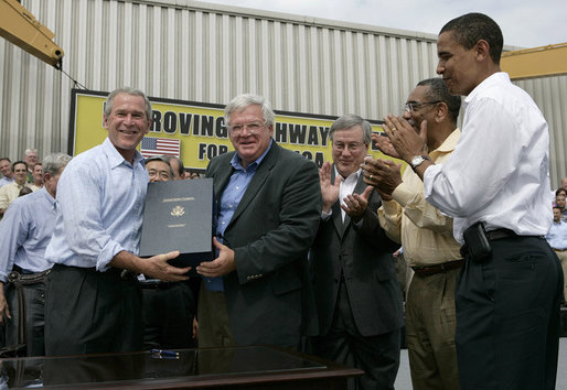 President George W. Bush holds the box after signing the Transportation Equity Act, with the help of Speaker of the House Dennis Hastert, R-Ill., at the Caterpillar facility in Montgomery, Ill., Wednesday, Aug. 10, 2005. Also pictured from left are Congressman Bill Thomas, R-Calif., Congressman Bobby Rush, D-Ill., and Senator Barack Obama, D-Ill. White House photo by Eric Draper
