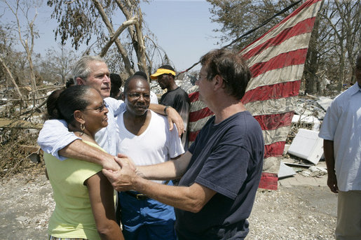 President George W. Bush embraces victims of Hurricane Katrina Friday, Sept. 2, 2005, during his tour of the Biloxi, Miss., area. " The President told residents that he had come down to look at the damage first hand and to tell the "good people of this part of the world that the federal government is going to help." White House photo by Eric Draper