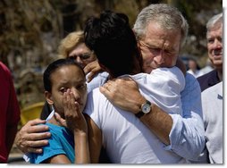 President George W. Bush comforts Bronwynne Bassier, right, and her sister Kim after landing in Biloxi, Miss., Friday Sept. 2, 2005, as part of his tour of the Hurricane Katrina-ravaged Gulf Coast. Their family lost everything in the wake of the devastating storm.  White House photo by Eric Draper