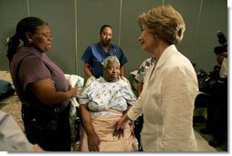 Laura Bush reaches out to a victim of Hurricane Katrina during a visit Friday, Sept. 2, 2005, to the Cajundome at the University of Louisiana in Lafayette. "The people of this part of the United States, the Lafayette area of Louisiana, are very, very warm people," said Mrs. Bush. "They've opened their hearts, and many of them have opened their homes, as well, to people from New Orleans -- family members and strangers."  White House photo by Krisanne Johnson