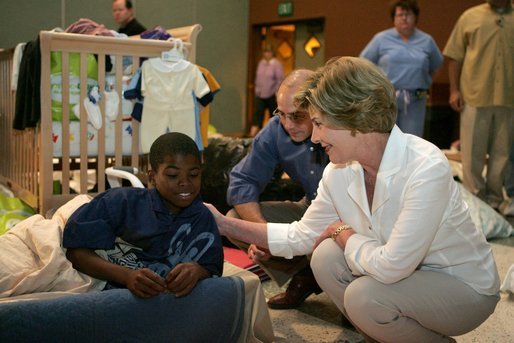 Laura Bush visits with a young boy displaced by Hurricane Katrina in the Cajundome at the University of Louisiana in Lafayette, La., Friday, Sept. 2, 2005. White House photo by Krisanne Johnson