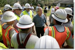 President George W. Bush talks with some workers of Alabama Power, who are helping to bring power back in service in Poplarville, Miss., Monday, Sept. 5, 2005. White House photo by Eric Draper