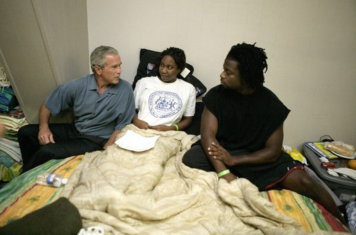 President George W. Bush visits with a family displaced by Hurricane Katrina, during his visit Monday, Sept. 5, 2005 at the Bethany World Prayer Center shelter in Baton Rouge, La. White House photo by Eric Draper