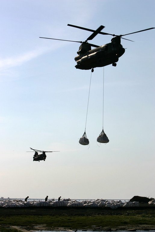 Helicopters lift sandbags that will be dropped into the area of the levee break to facilitate repairs to 17th street levee in New Orleans, Louisiana Thursday, September 8, 2005. White House photo by David Bohrer