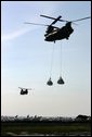 Helicopters lift sandbags that will be dropped into the area of the levee break to facilitate repairs to 17th street levee in New Orleans, Louisiana Thursday, September 8, 2005. White House photo by David Bohrer