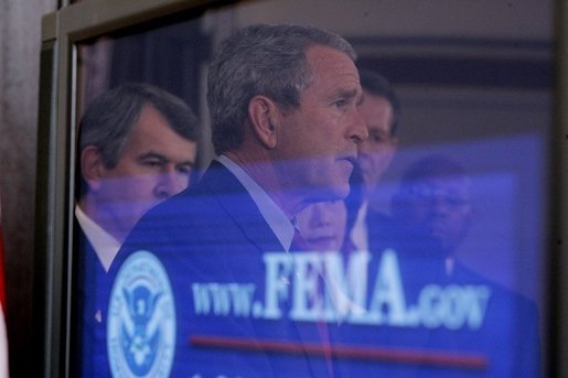 President George W. Bush's reflection is seen in a television monitor as he outlines further assistance to victims of Hurricane Katrina, Thursday, Sept. 8, 2005 in the Eisenhower Executive Office Building in Washington. White House photo by Paul Morse
