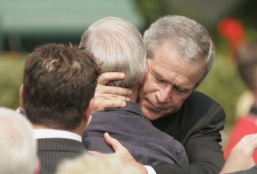 President George W. Bush embraces one of the hundreds of family and friends who gathered on the South Lawn of the White House, Friday, Sept. 9, 2005, during the 9/11 Heroes Medal of Valor Award Ceremony, in honor of the courage and commitment of emergency services personnel who died on Sept. 11, 2001. White House photo by Paul Morse