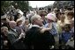 President George W. Bush holds Keira Corrigan of Mineola, N.Y., as he meets some of the hundreds of family and friends who gathered on the South Lawn of the White House, Friday, Sept. 9, 2005, during the 9/11 Heroes Medal of Valor Award Ceremony, in honor of the courage and commitment of emergency services personnel who died on Sept. 11, 2001. White House photo by Eric Draper