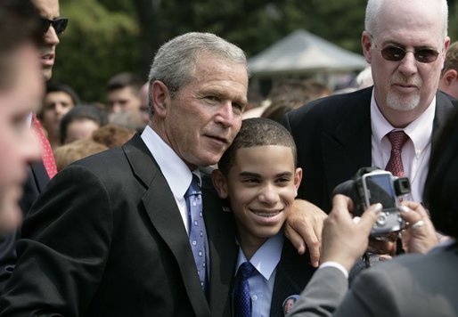 President George W. Bush poses for a photo with a young man wearing a button in honor of 9/11 victim, Yamel J. Merino, as he met some of the hundreds of families and friends who gathered on the South Lawn of the White House, Friday, Sept. 9, 2005, during the 9/11 Heroes Medal of Valor Award Ceremony, in honor of the courage and commitment of emergency services personnel who died on Sept. 11, 2001. White House photo by Eric Draper