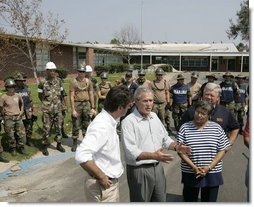 President George W. Bush is joined by Gulfport, Miss., Mayor Brent Warr, left; Twenty-Eighth Street Elementary School principal Phyllis A Bourn and Mississippi Gov. Haley Barbour, right, Monday, Sept. 12, 2005, outside the Twenty-Eighth Street Elementary School in Gulfport, where U.S. and Mexico aid workers are helping to clean-up the school devastated by Hurricane Katrina.  White House photo by Paul Morse