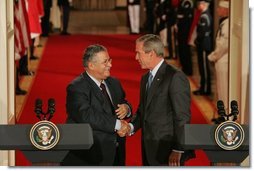 President George W. Bush shakes hands with President Jalal Talabani of Iraq after their joint press availability Tuesday, Sept. 13, 2005, in the East Room of the White House.  White House photo by Shealah Craighead