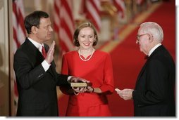 Judge John G. Roberts is sworn-in as the 17th Chief Justice of the United States by Associated Supreme Court Justice John Paul Stevens, Thursday, Sept. 29, 2005 in the East Room of the White House in Washington. Judge Roberts' wife Jane is seen holding the Bible.  White House photo by Paul Morse